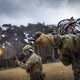 Soldiers firing rifles while using the CM-7M Military Gas Mask