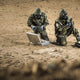 Two soldiers testing ground samples with the CM-7M warfare mask