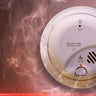 Smoke and carbon monoxide detector on a wall with visible smoke, ensuring home safety from CO leaks and fire hazards.