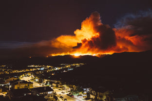 Large wildfire approaching residential homes during high wind conditions