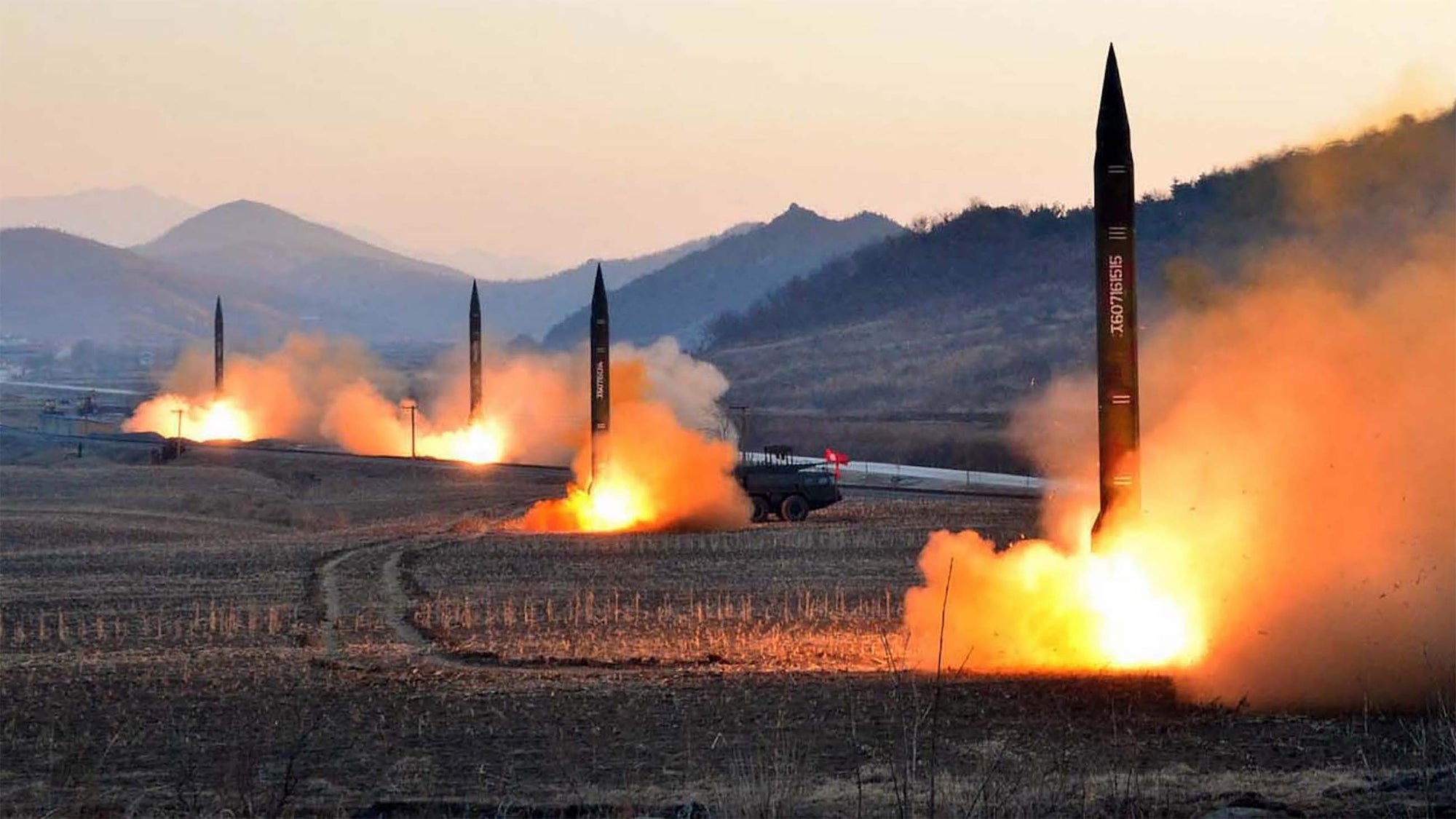 Missiles being launched amid mountain scene