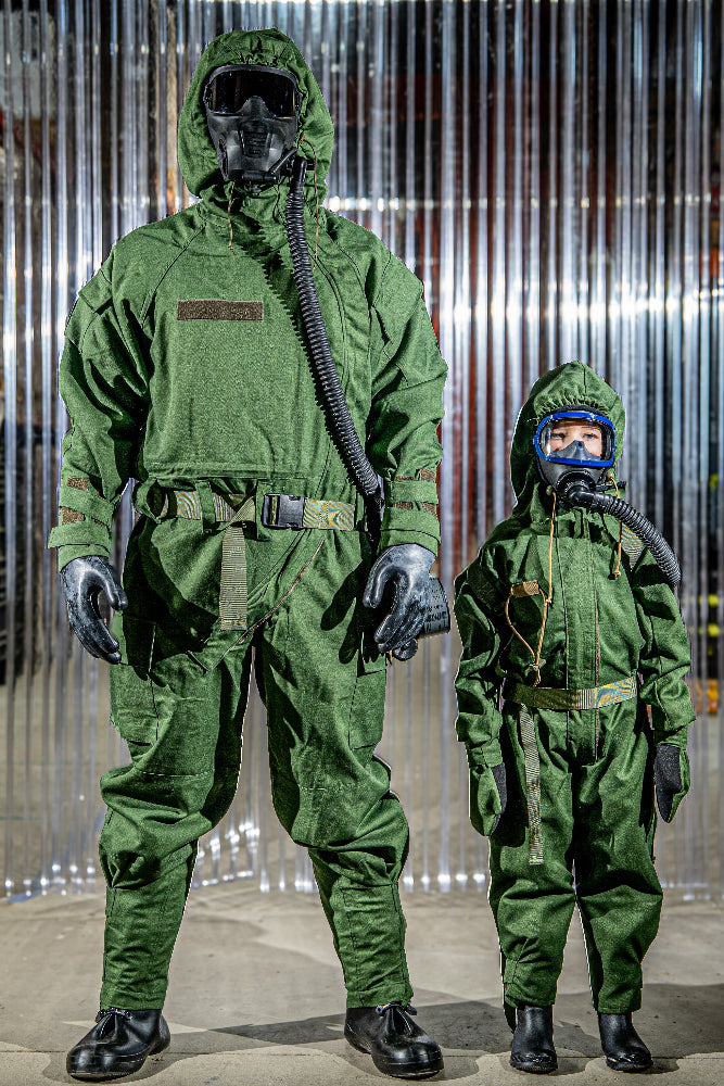Two individuals wearing green protective suits with hoods against a metallic background