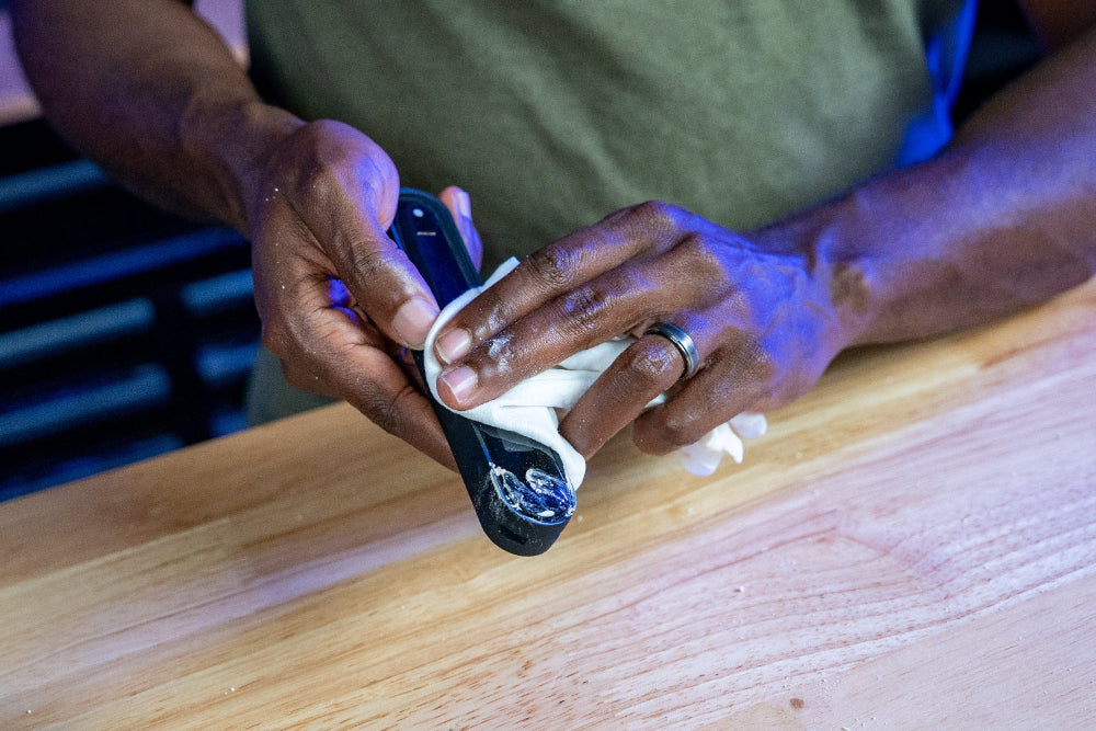 Person using a garlic press on a wooden surface