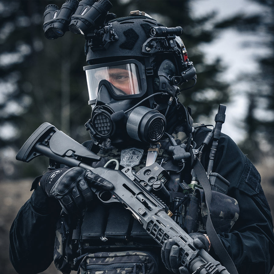 3/4 medium shot view of an operator wearing tactical equipment and gas mask, with a NBC-17 filter and shotgun