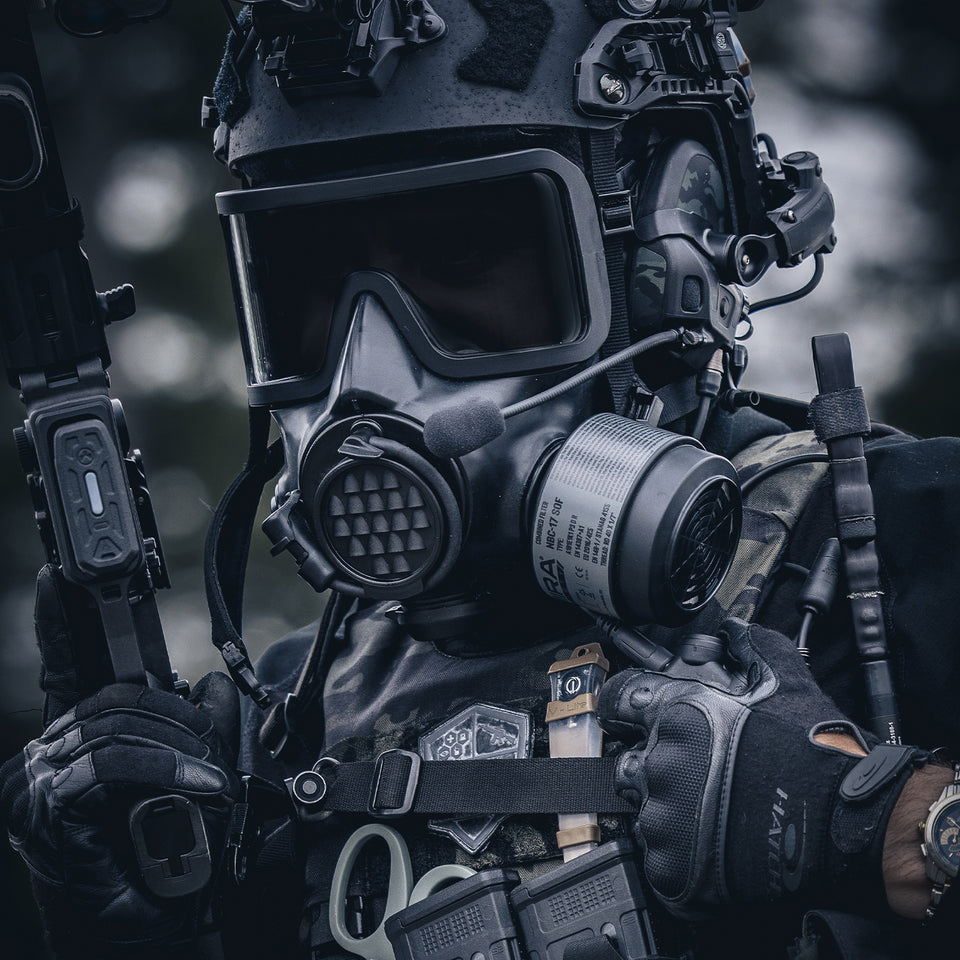 A close up 3/4 shot of an operator in full tactical equipment, with a gas mask and NBC-17 filter