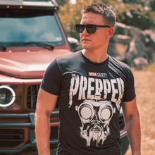 Side profile shot of a man wearing The Prepper T shirt with sunglasses on, standing in front of a red jeep.