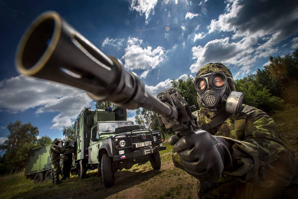 Solider using the NBC-77 SOF CBRN gas mask filter with a firearm