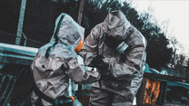 Father and child wearing full CBRN PPE