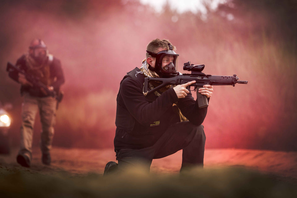 Man shooting a rifle while wearing the MIRA Safety CM-6M tactical gas mask