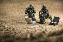 Two soldiers testing ground samples with the CM-7M warfare mask
